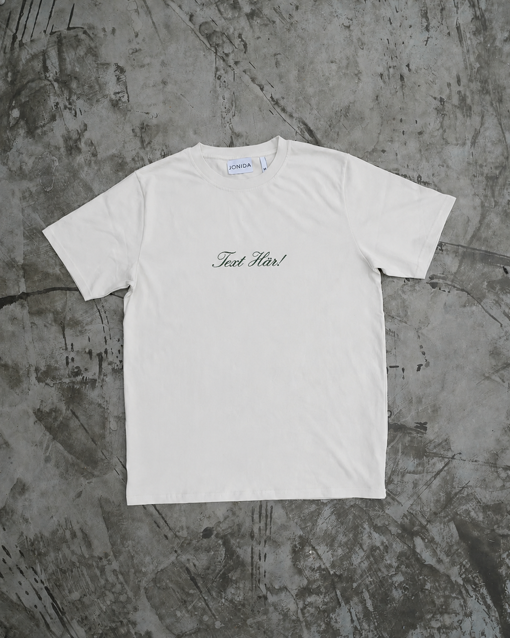Liten broderad text på en vit t-shirt. 