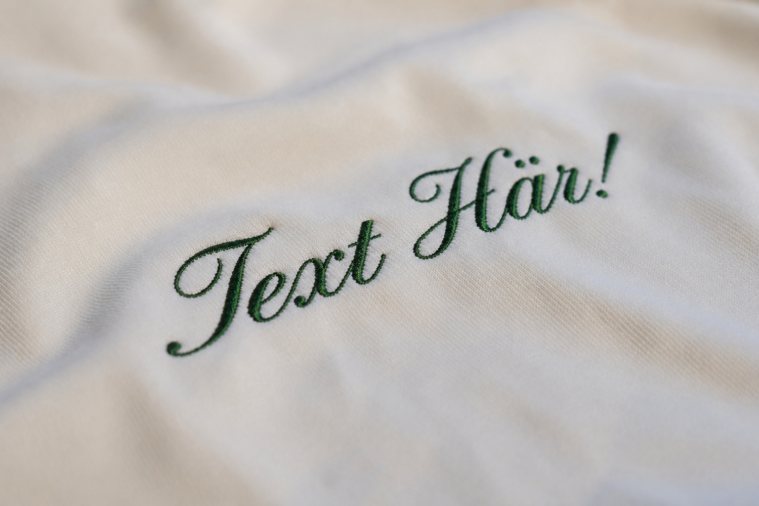 Broderad grön text på t-shirt. 